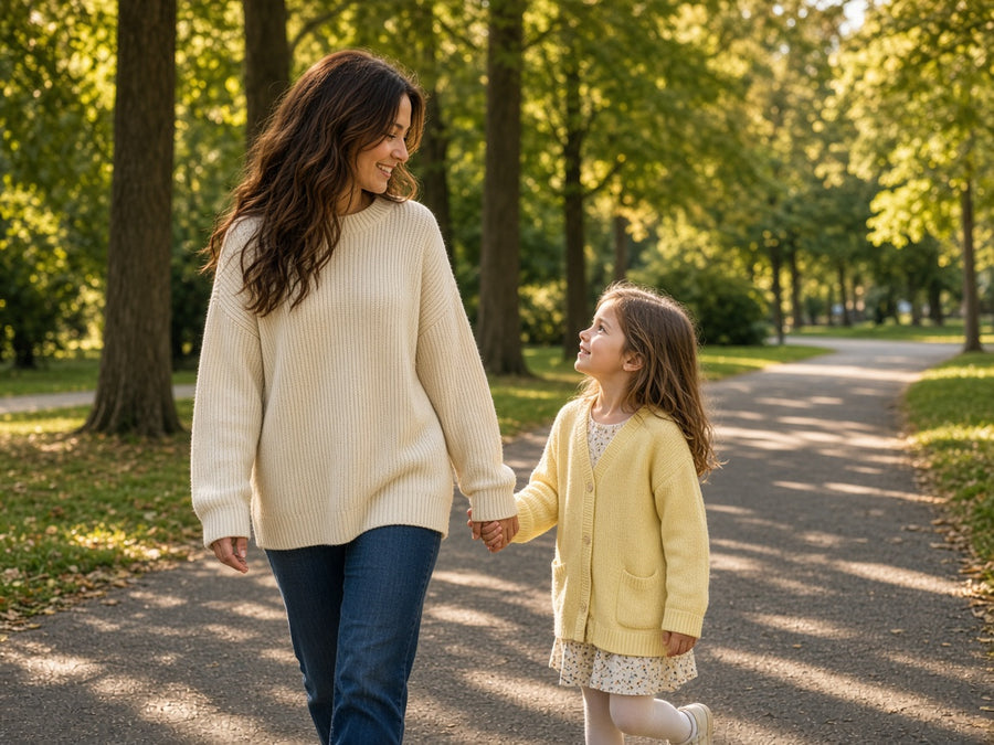 A mother and child walk together in a park